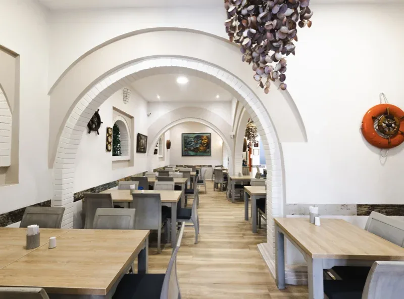Comedor con arcos blancos, salvavidas y lámpara de conchas en Pescocentro Búcaro, Bucaramanga
